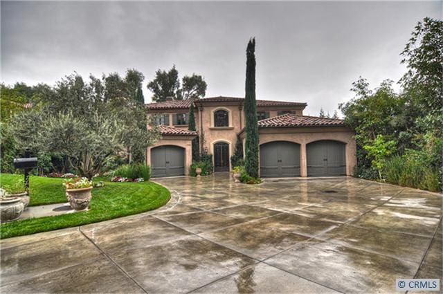 mediterranean / spanish-style home with a garage