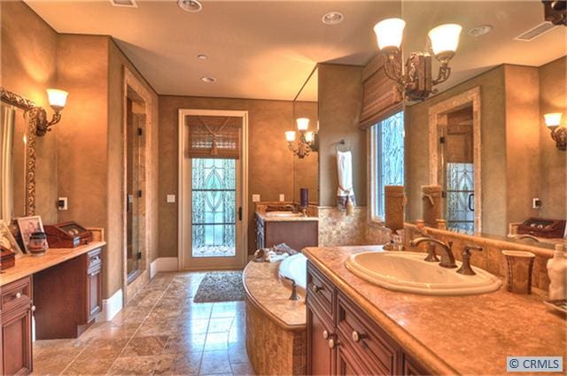 bathroom with a chandelier, vanity, and independent shower and bath