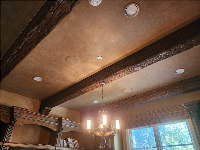 room details featuring a chandelier and beam ceiling