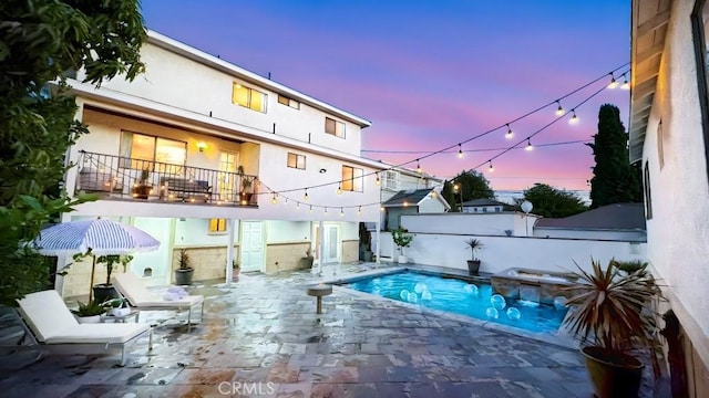 pool at dusk with a patio