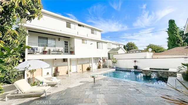 rear view of house with a patio area, a balcony, and a fenced in pool