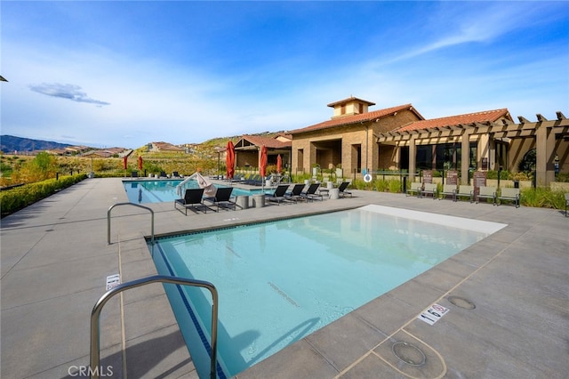 view of swimming pool featuring a patio, a pergola, and a mountain view