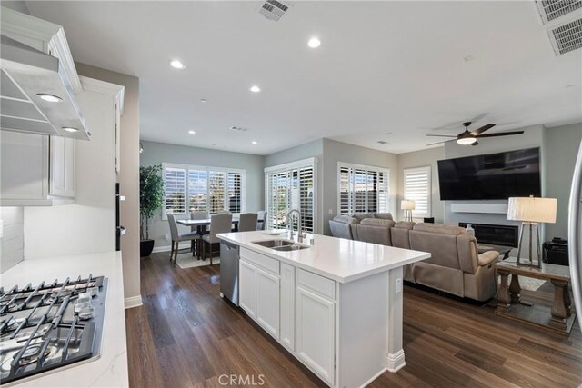 kitchen with stainless steel appliances, sink, dark hardwood / wood-style floors, a kitchen island with sink, and white cabinets