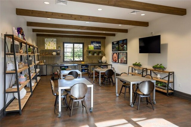 dining area featuring dark wood-type flooring and beam ceiling