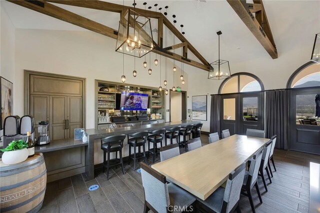 dining room with high vaulted ceiling, dark hardwood / wood-style flooring, and beamed ceiling