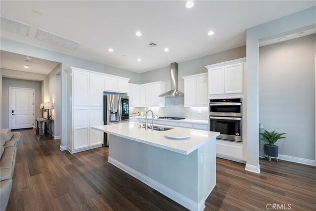 24185 Sprout Dr, Corona, CA 92883 - kitchen with light countertops, a sink, wall chimney exhaust hood, stainless steel appliances, and a kitchen island with sink