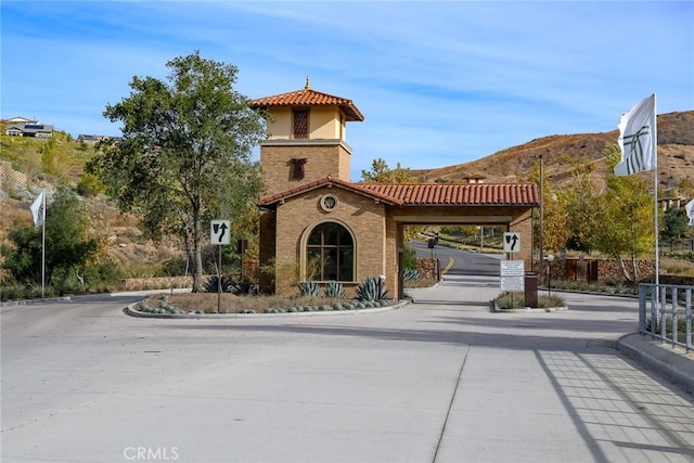 24185 Sprout Dr, Corona, CA 92883 - exterior space featuring a gated entry, curbs, and traffic signs