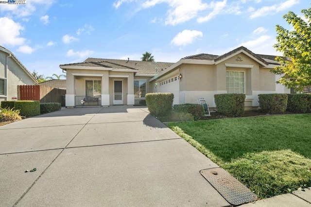 ranch-style house featuring a porch, a garage, and a front yard