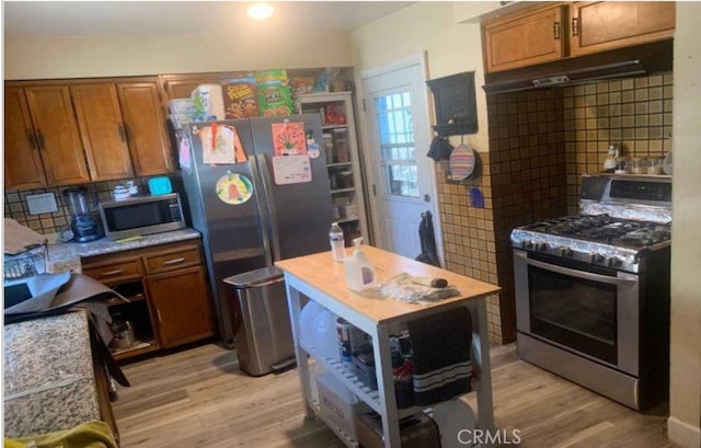 kitchen featuring backsplash, stainless steel appliances, and light hardwood / wood-style flooring