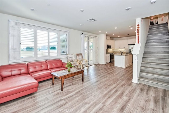 living room with light wood-type flooring and sink