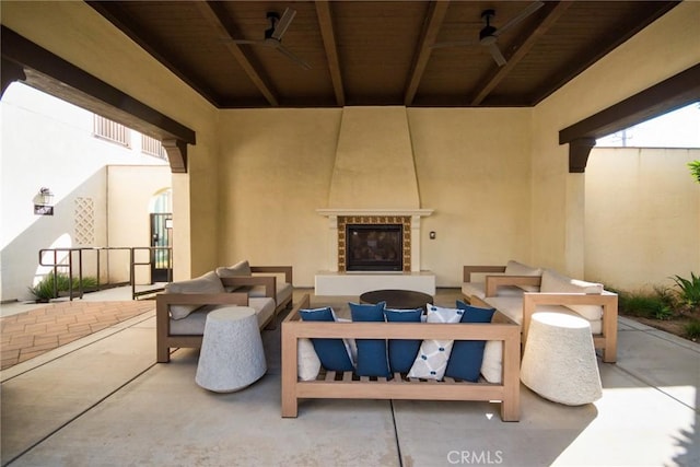 view of patio with an outdoor living space with a fireplace and ceiling fan