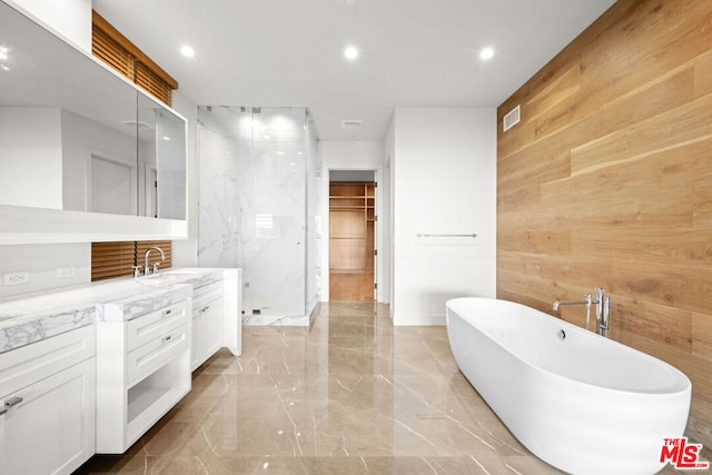 bathroom featuring vanity, shower with separate bathtub, and wooden walls