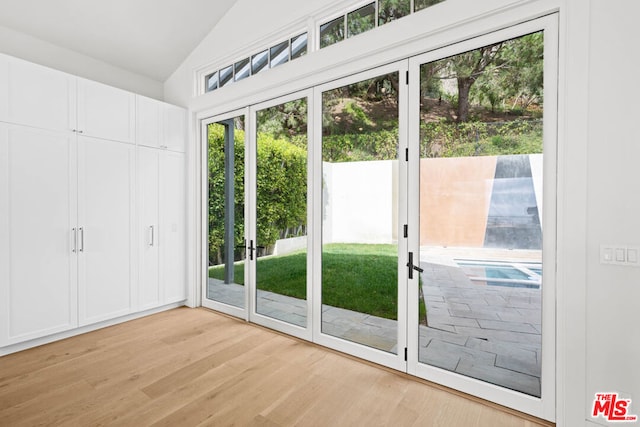 entryway featuring vaulted ceiling and light hardwood / wood-style flooring