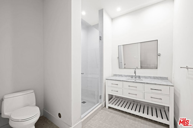 bathroom with toilet, a shower with shower door, and vanity