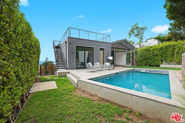 rear view of house featuring a patio area, a fenced in pool, a yard, and an outdoor hangout area