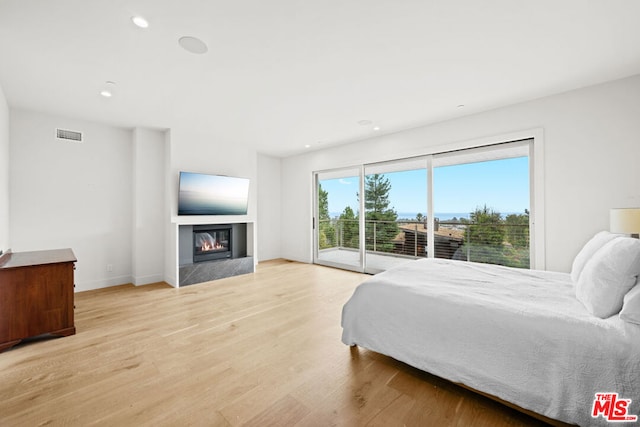 bedroom with light wood-type flooring and access to outside