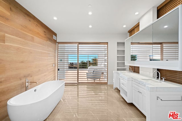 bathroom featuring vanity, a tub, built in features, and wooden walls