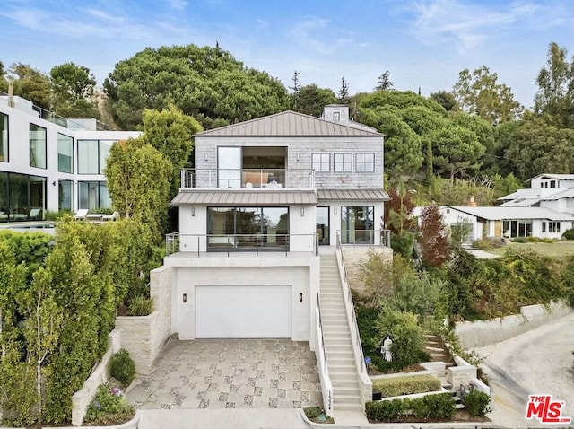 view of front of property featuring a garage and a balcony