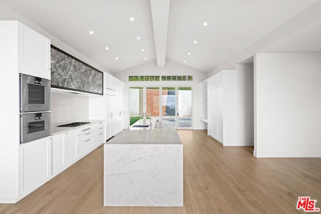 kitchen featuring a center island with sink, beam ceiling, white cabinets, and sink