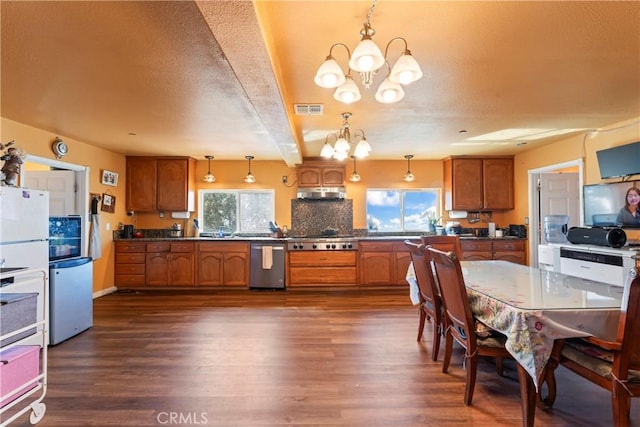 kitchen featuring pendant lighting, a healthy amount of sunlight, dark hardwood / wood-style flooring, and an inviting chandelier