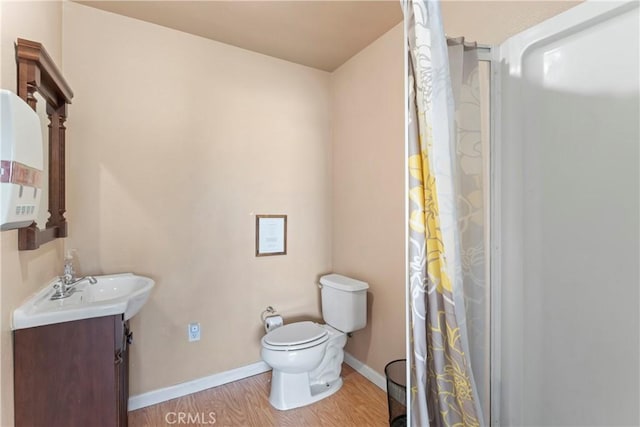 bathroom with vanity, toilet, and wood-type flooring