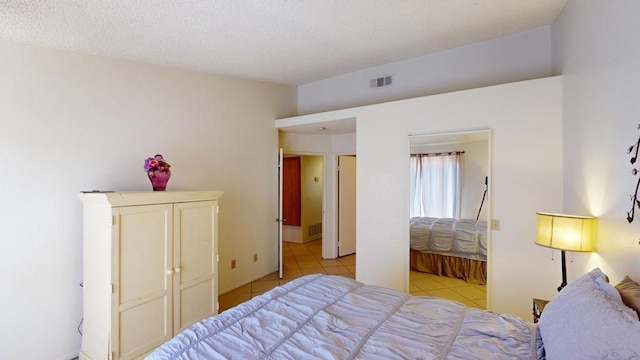 tiled bedroom featuring a textured ceiling