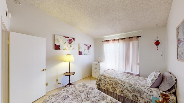 tiled bedroom featuring a textured ceiling and vaulted ceiling