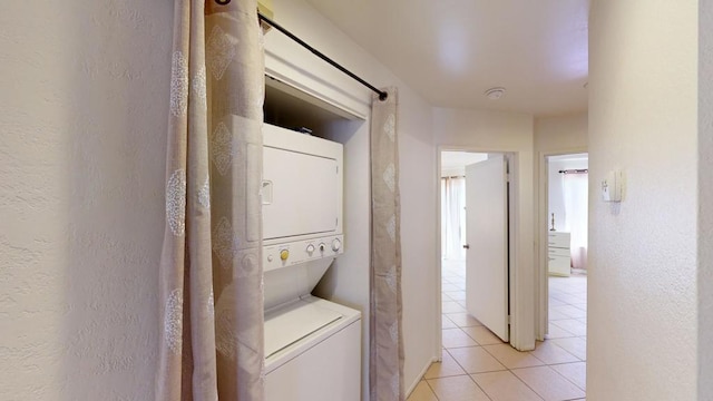 washroom with light tile patterned floors and stacked washer and clothes dryer