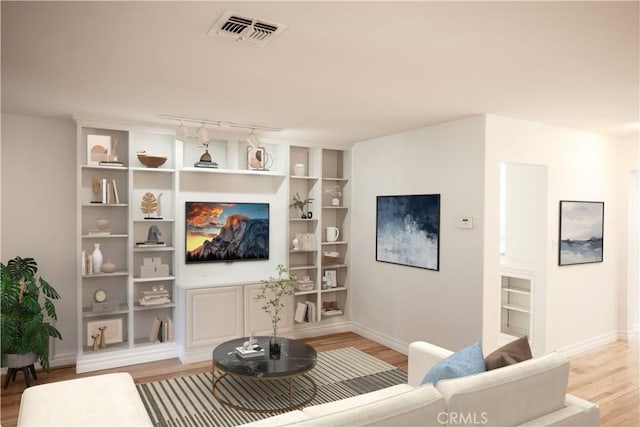 living room with built in features and light hardwood / wood-style flooring