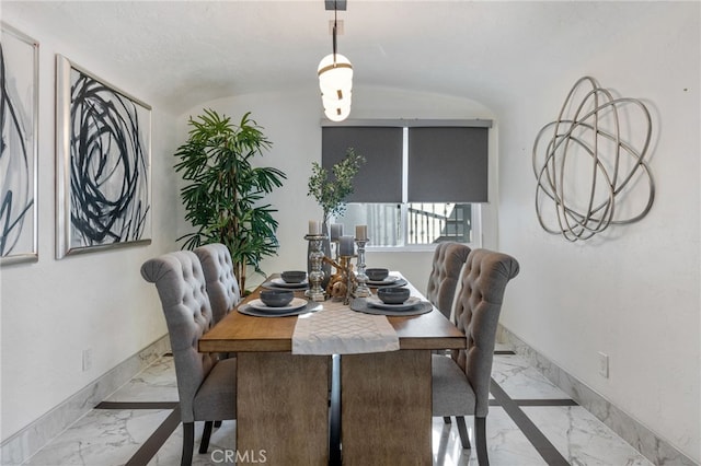 dining space featuring a textured ceiling and vaulted ceiling