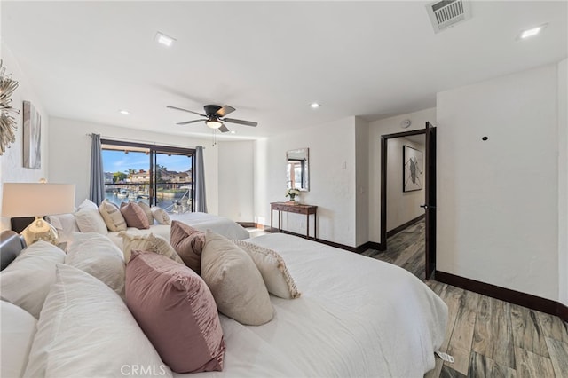 bedroom with dark hardwood / wood-style flooring and ceiling fan