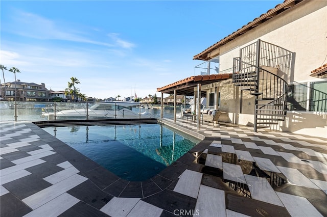 view of swimming pool with a water view and a patio