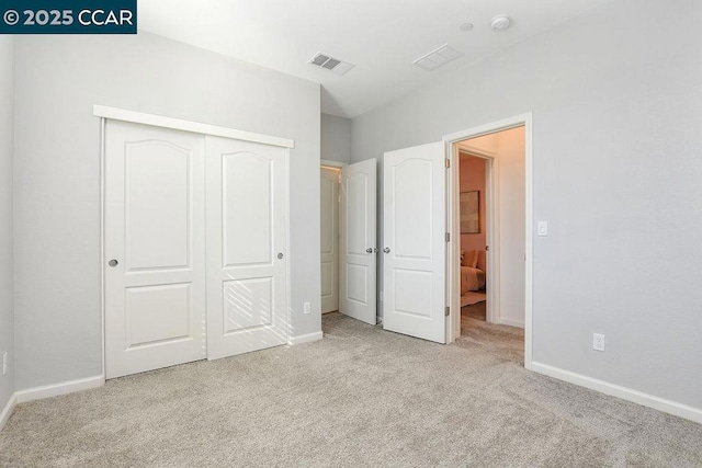 unfurnished bedroom with light carpet and a closet