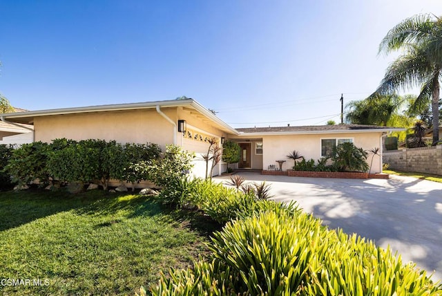 ranch-style home with a garage and a front yard