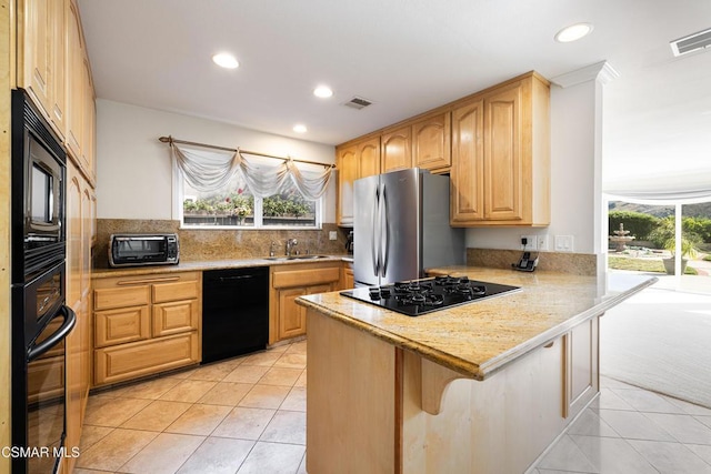 kitchen featuring black appliances, sink, a kitchen breakfast bar, light tile patterned floors, and kitchen peninsula