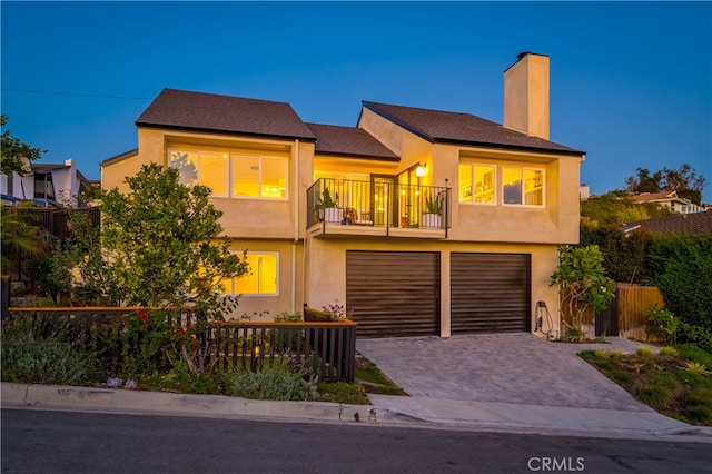 view of front of property featuring a garage and a balcony