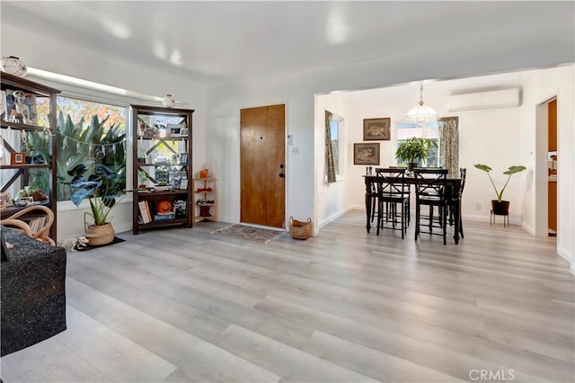 interior space with light wood-type flooring and a wall unit AC