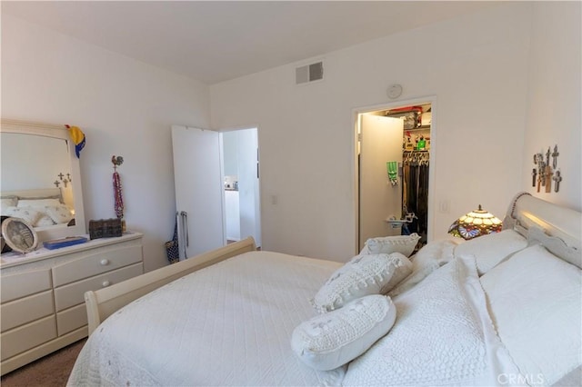 bedroom featuring a walk in closet, a closet, and carpet