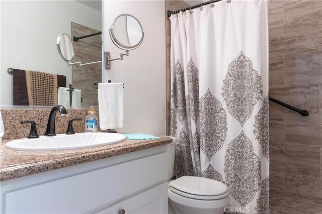 bathroom with toilet, vanity, and a shower with shower curtain