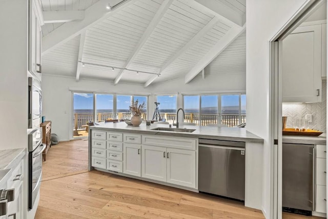 kitchen featuring white cabinets, lofted ceiling with beams, sink, light wood-type flooring, and stainless steel appliances