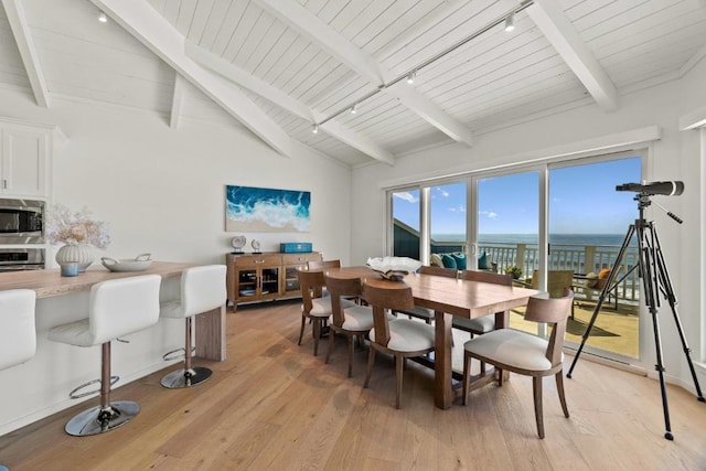 dining space with vaulted ceiling with beams, light hardwood / wood-style floors, a water view, and wooden ceiling