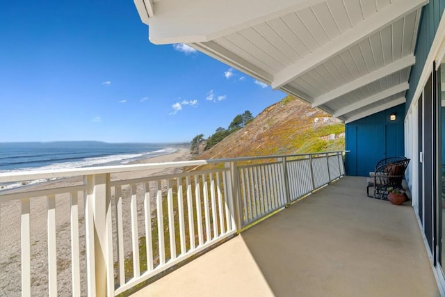 balcony with a water view and a beach view