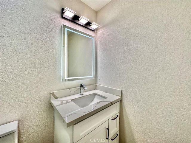 bathroom featuring vanity and toilet