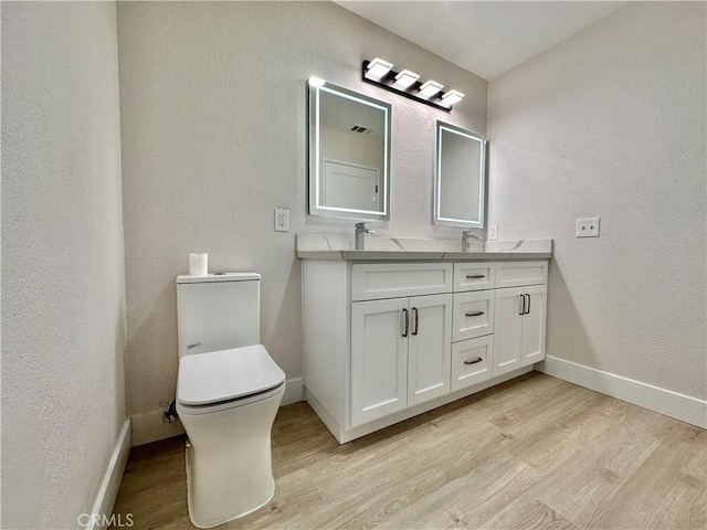 bathroom with hardwood / wood-style flooring, vanity, and toilet