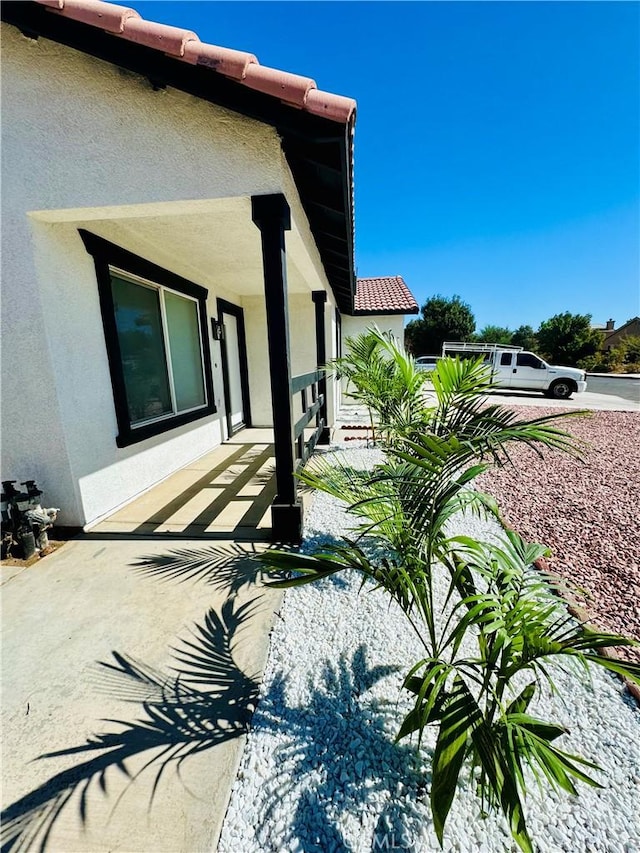 view of side of home with covered porch