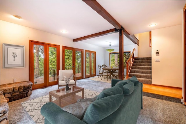 living room featuring beam ceiling, carpet floors, and french doors