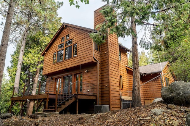 back of house featuring central AC unit and a deck