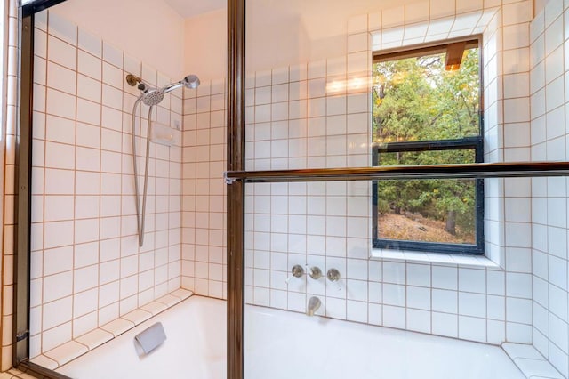 bathroom with shower / bath combination with glass door and a healthy amount of sunlight