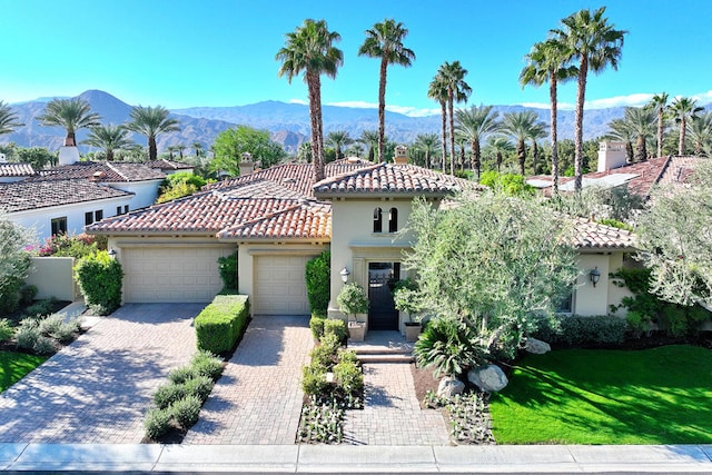 mediterranean / spanish-style home with a front yard, a garage, and a mountain view