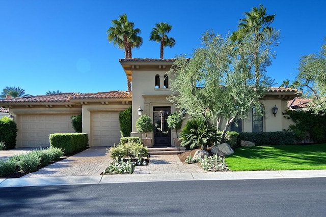 mediterranean / spanish-style home with a front lawn and a garage